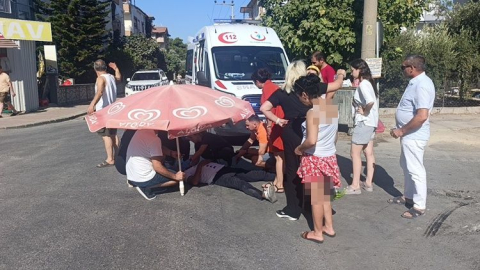 Kaza yapan motosiklet sürücüsünü plaj şemsiyesiyle korudular